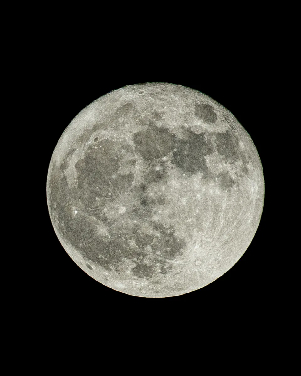Vollmond mit deutlich sichtbaren Kratern und dunklen Mare-Regionen vor schwarzem Hintergrund.